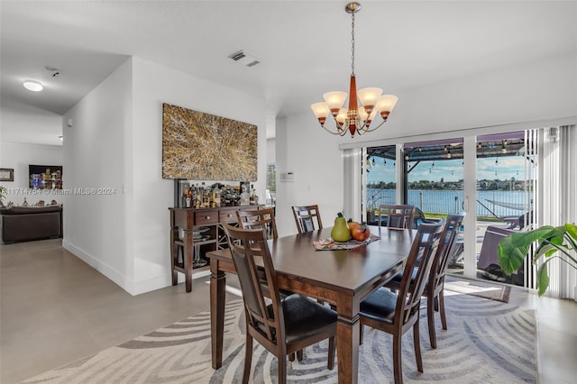 dining room featuring a water view and an inviting chandelier