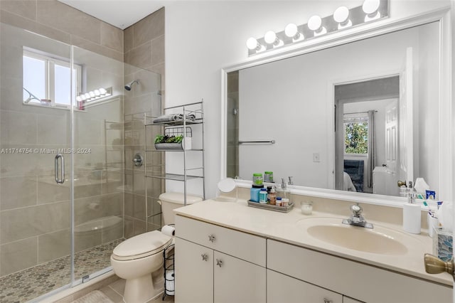 bathroom featuring vanity, toilet, and a shower with door