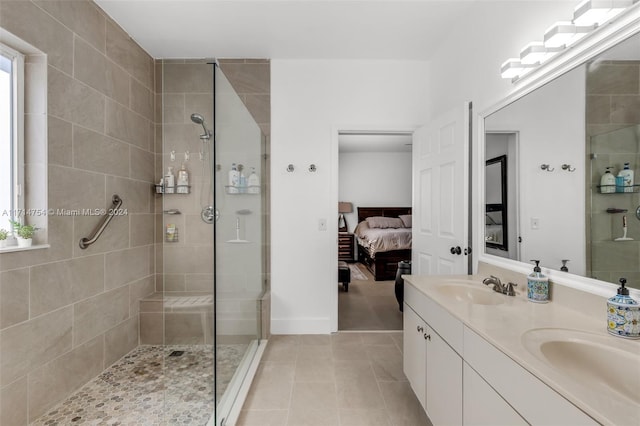 bathroom featuring tile patterned flooring, a tile shower, and vanity