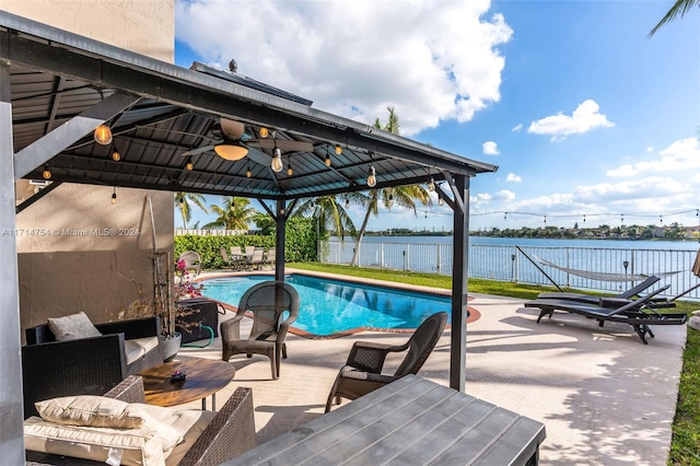 view of swimming pool featuring a gazebo, ceiling fan, a patio area, and a water view