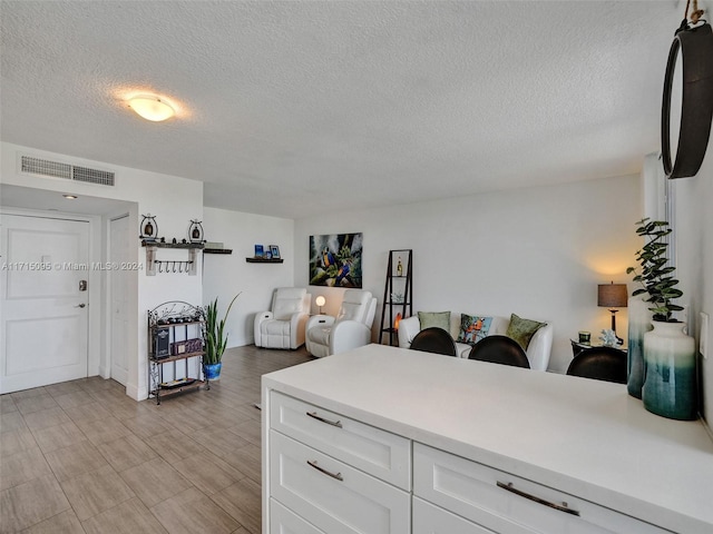 kitchen with white cabinets and a textured ceiling