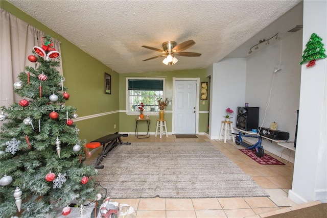 interior space featuring ceiling fan, lofted ceiling, and a textured ceiling