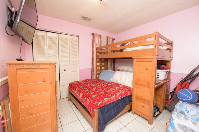 tiled bedroom featuring a closet and a textured ceiling