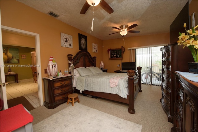 carpeted bedroom with ceiling fan, access to exterior, and a textured ceiling