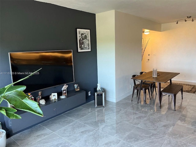 living area featuring marble finish floor and baseboards