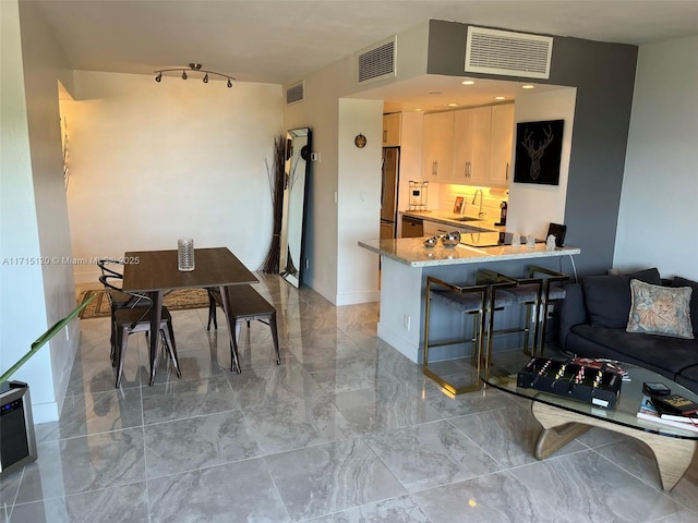 kitchen with marble finish floor, visible vents, and light stone counters