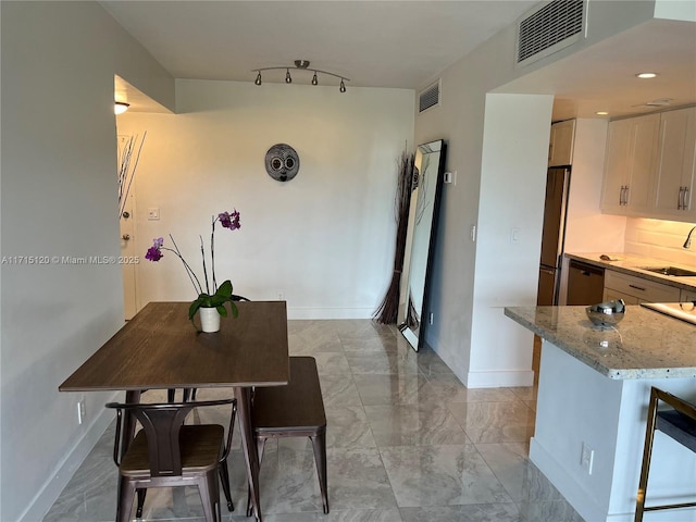 dining space with visible vents, baseboards, rail lighting, and marble finish floor