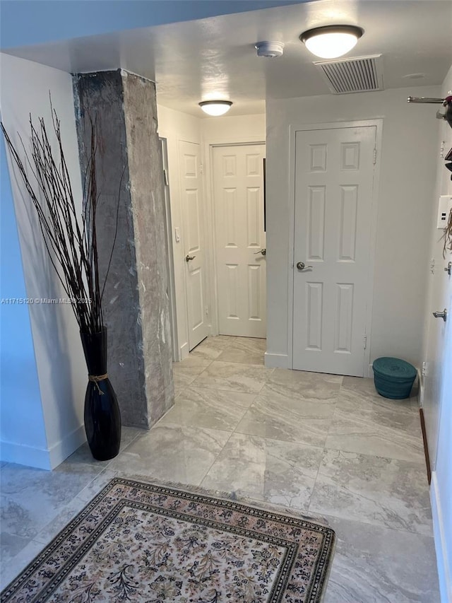 corridor featuring visible vents and baseboards