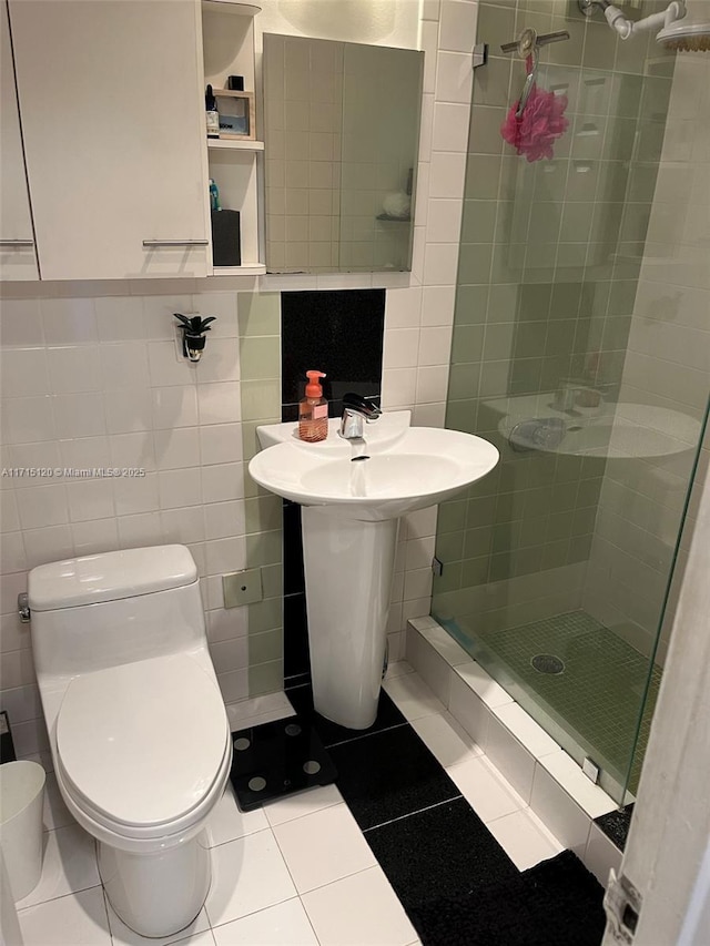 bathroom featuring tile walls, a shower stall, toilet, and tile patterned floors