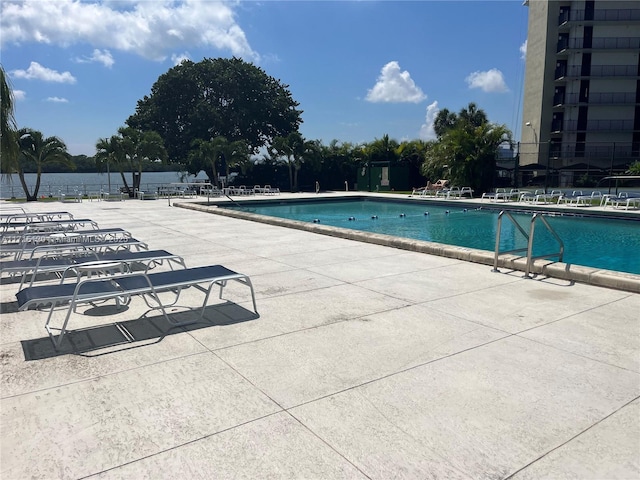 pool with a patio area and fence