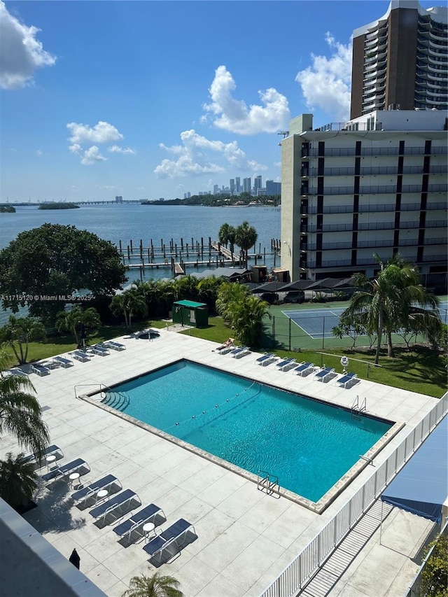 pool featuring a patio, a water view, a dock, cooling unit, and a city view