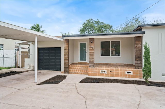 view of front facade featuring covered porch, a garage, and a carport