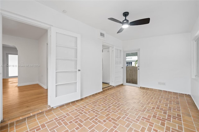 spare room featuring built in shelves and ceiling fan