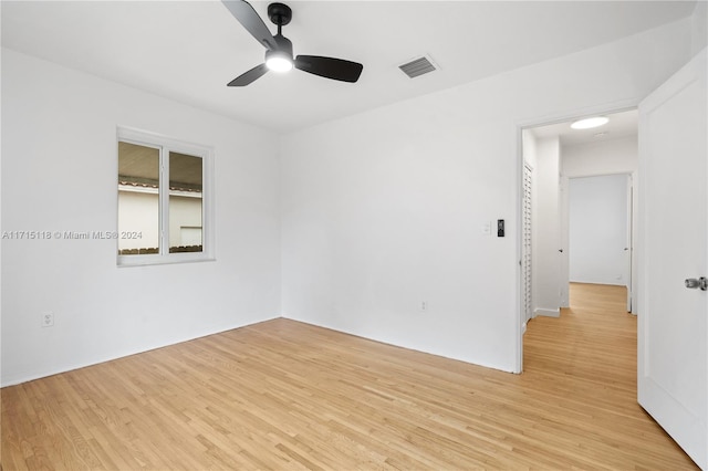 empty room with ceiling fan and light hardwood / wood-style flooring