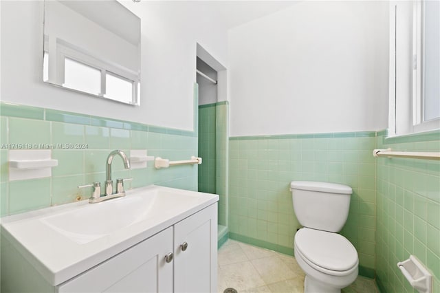 bathroom featuring tile patterned flooring, vanity, toilet, and tile walls