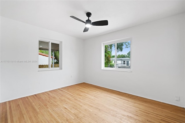 empty room featuring light wood-type flooring, plenty of natural light, and ceiling fan