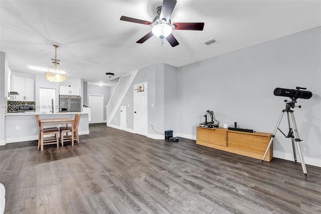 living room featuring dark hardwood / wood-style flooring and ceiling fan