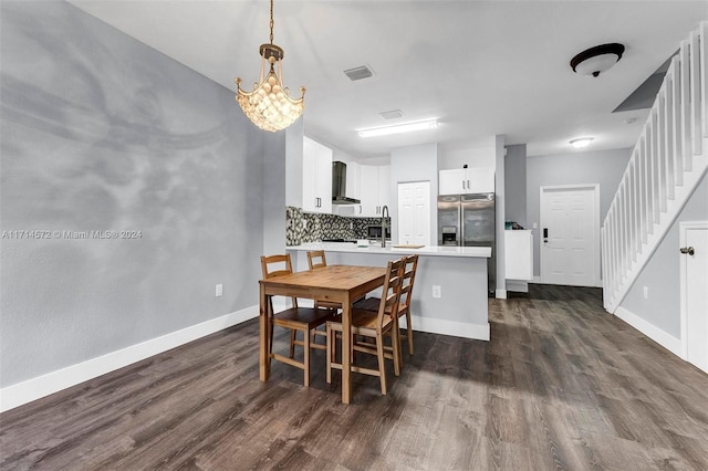 dining room with dark hardwood / wood-style flooring and a notable chandelier