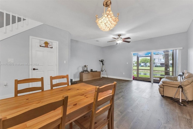 dining space featuring ceiling fan with notable chandelier and dark wood-type flooring