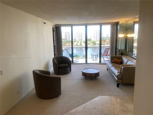 living room with floor to ceiling windows, a water view, and a textured ceiling