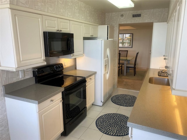 kitchen with black appliances, white cabinetry, sink, and light tile patterned floors