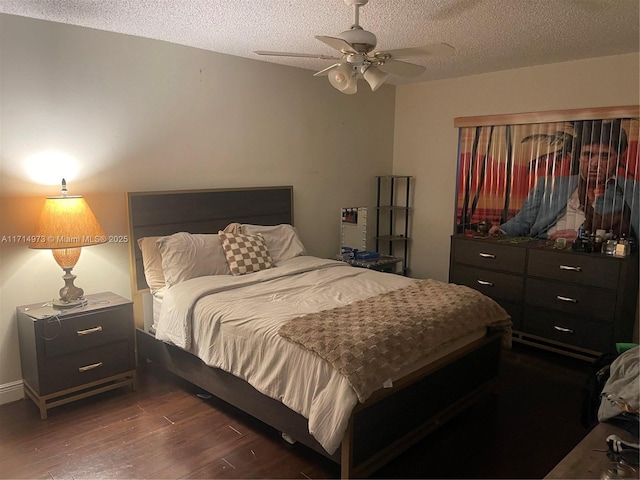 bedroom with ceiling fan, dark wood-type flooring, and a textured ceiling