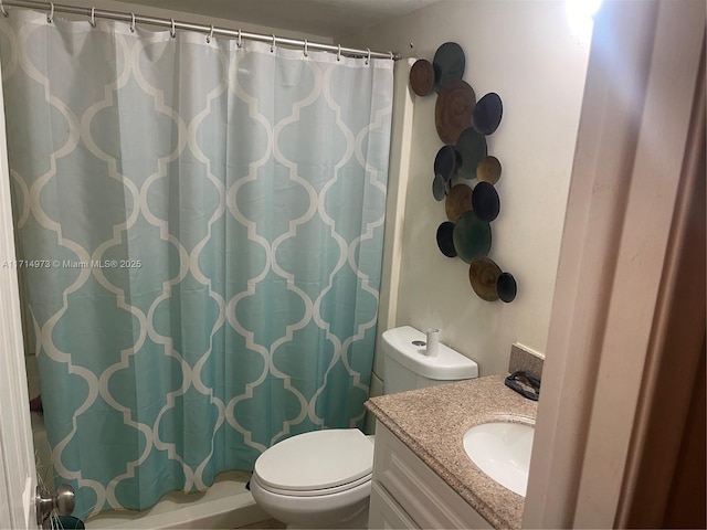 bathroom with curtained shower, vanity, and toilet