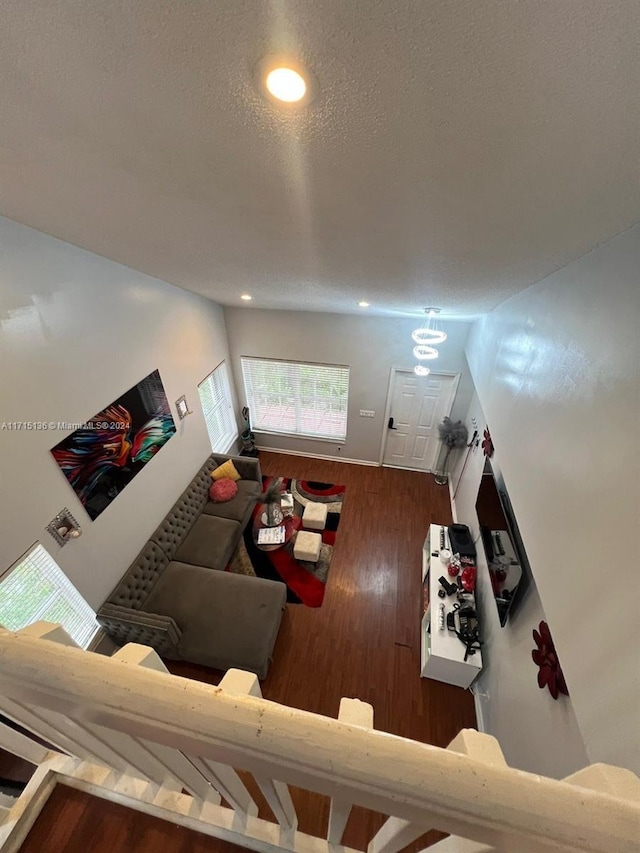 living room with a textured ceiling and dark wood-type flooring