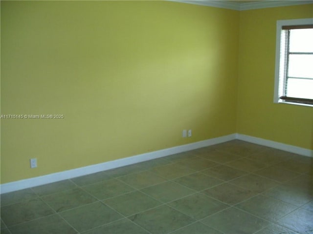 tiled spare room featuring crown molding