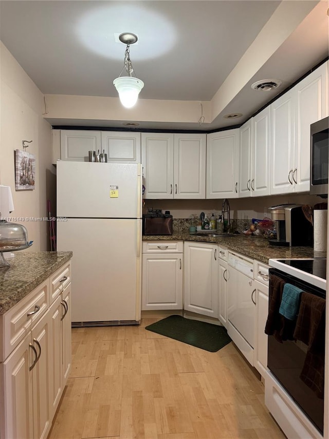 kitchen with white cabinetry, sink, hanging light fixtures, and white appliances