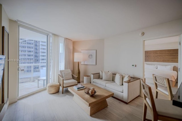 living room with light hardwood / wood-style floors and a wall of windows