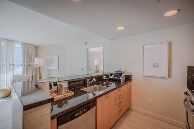 kitchen with kitchen peninsula, appliances with stainless steel finishes, dark stone counters, and sink