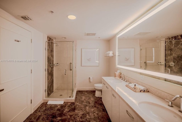 bathroom with vanity, a shower with shower door, and toilet