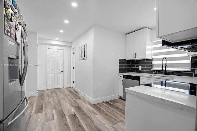 kitchen featuring light stone countertops, appliances with stainless steel finishes, tasteful backsplash, sink, and white cabinets