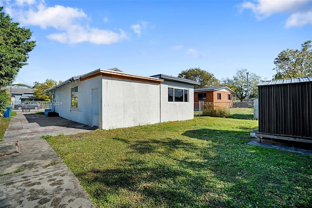 view of home's exterior with a patio area and a yard