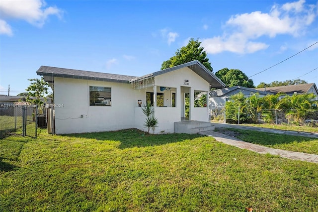 view of front of house featuring cooling unit, a front lawn, and a porch