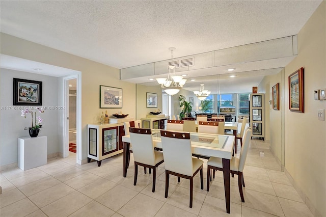 tiled dining space with a notable chandelier and a textured ceiling