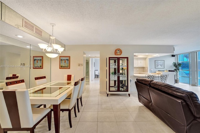 dining area featuring light tile patterned floors, a textured ceiling, and a notable chandelier