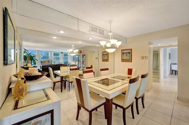 dining area featuring a textured ceiling, a notable chandelier, and light tile patterned flooring