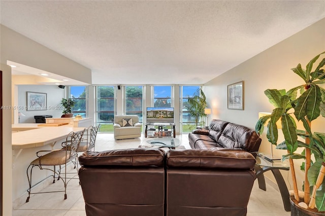 tiled living room featuring floor to ceiling windows, a wealth of natural light, and a textured ceiling