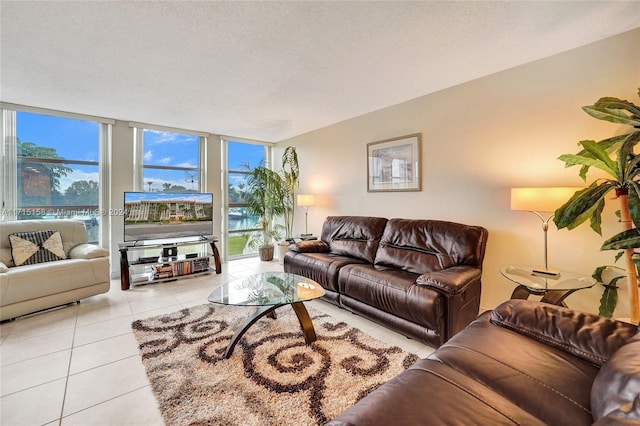 living room with floor to ceiling windows, light tile patterned flooring, and a textured ceiling