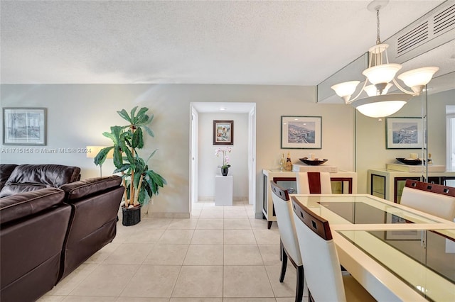 kitchen featuring pendant lighting, light tile patterned flooring, a textured ceiling, and a chandelier