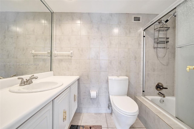 full bathroom with vanity, shower / bath combination with glass door, tile walls, tile patterned flooring, and toilet