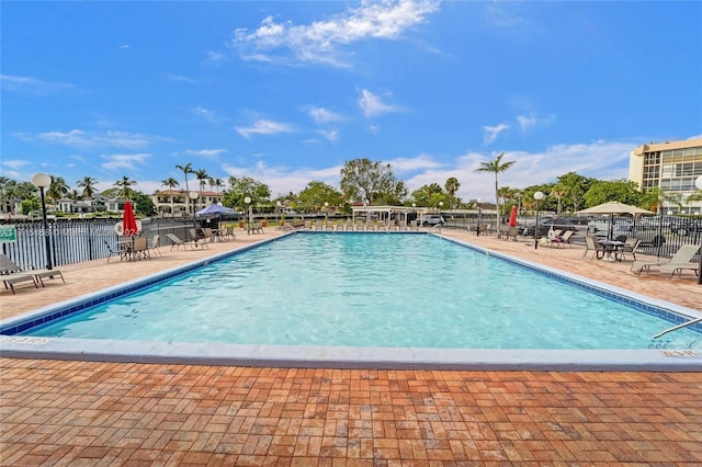 view of pool with a water view and a patio