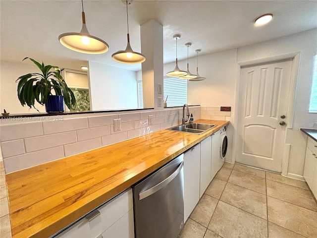 kitchen with butcher block countertops, decorative light fixtures, a sink, white cabinetry, and stainless steel dishwasher