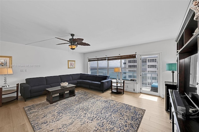 living room with ceiling fan, light wood-type flooring, and plenty of natural light