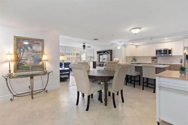 tiled dining space with ceiling fan