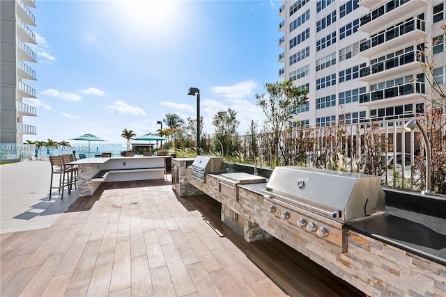 view of patio / terrace with a water view, exterior kitchen, and grilling area