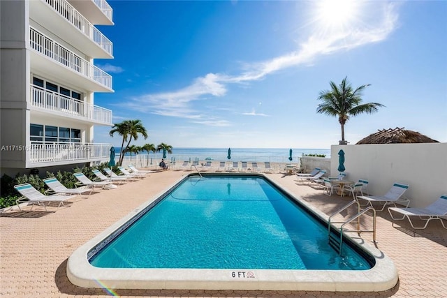 pool featuring a patio and a water view