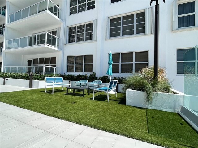 3750 Galt Ocean Dr Unit 1602, Fort Lauderdale, FL 33308 - rear view of property with stucco siding, a lawn, and an outdoor living space